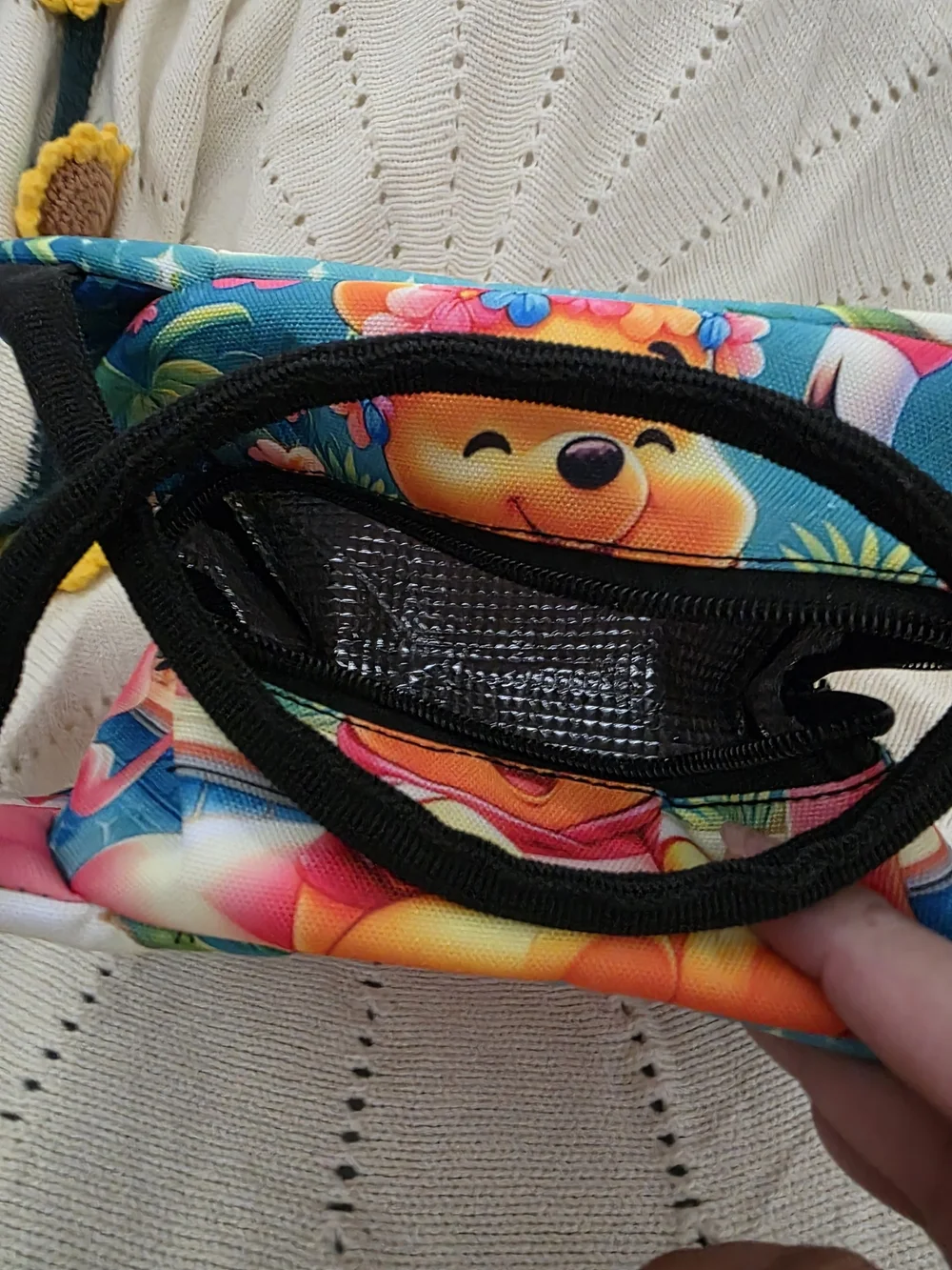 Insulated lunch bag features a playful design of Winnie the Pooh wearing a color